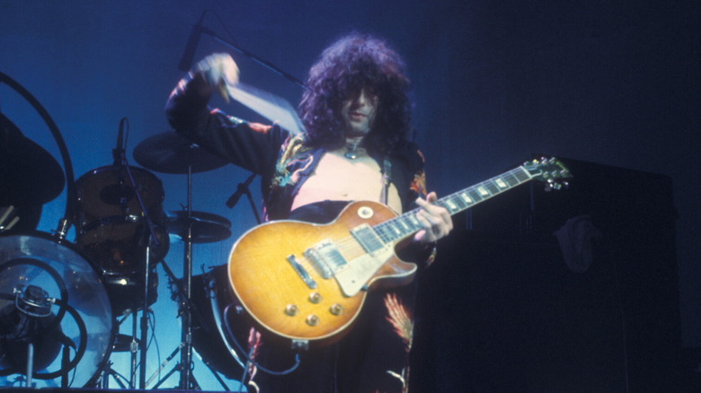 Jimmy Page playing a Les Paul with a bow on stage