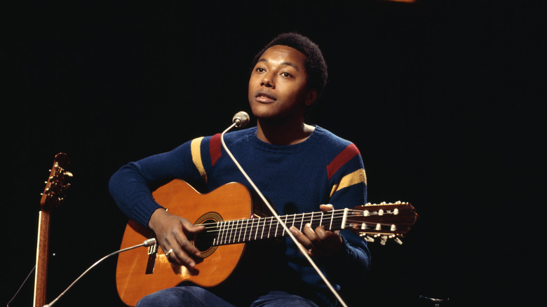 Labi Siffre sat playing guitar on stage