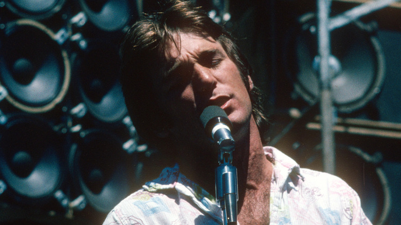 Dennis Wilson singing on stage with eyes closed