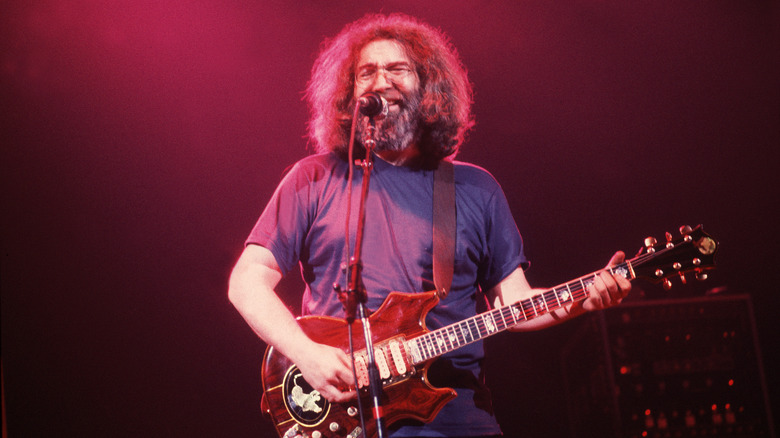 Jerry Garcia playing guitar and singing on stage