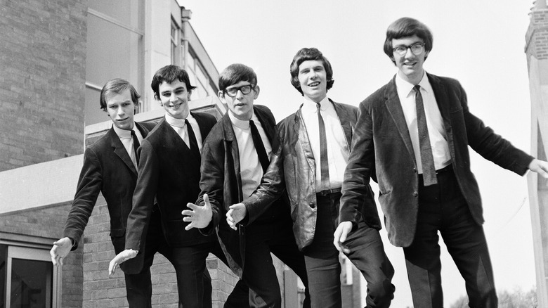 British band The Zombies posing in suits on a low wall 1965