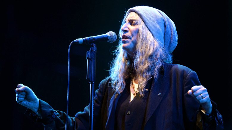 Patti Smith singing in wooly hat on stage