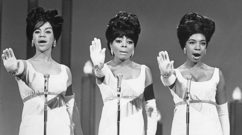 The Supremes singing in white dresses on stage