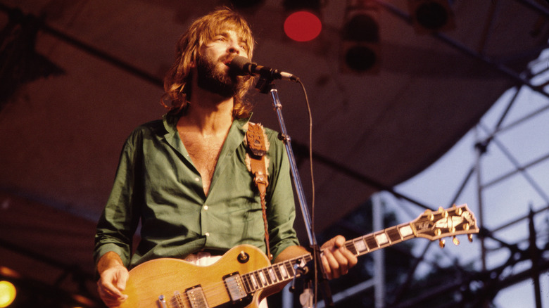 Kenny Loggins playing guitar and singing onstage.