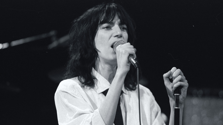 Patti Smith singing in white shirt on stage