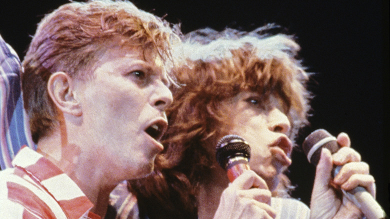 David Bowie and Mick Jagger onstage with microphones