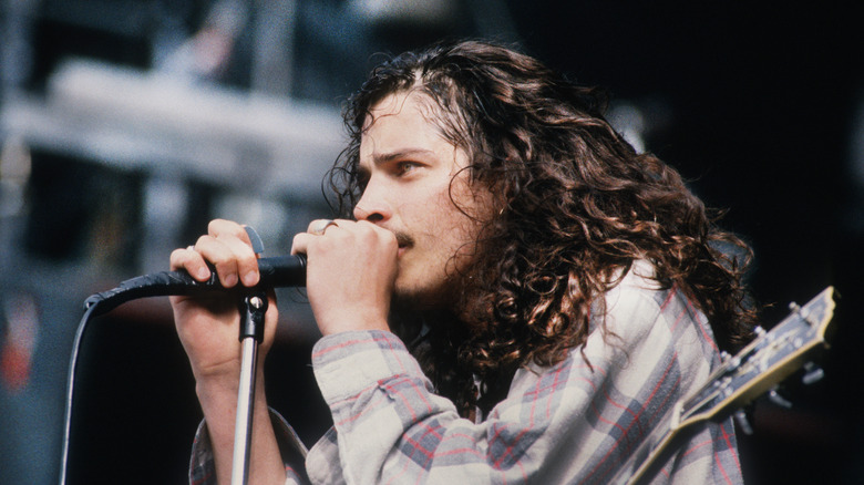 Chris Cornell holding microphone on stage with sweaty hair
