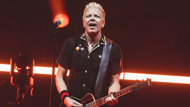 Dexter Holland playing guitar on stage