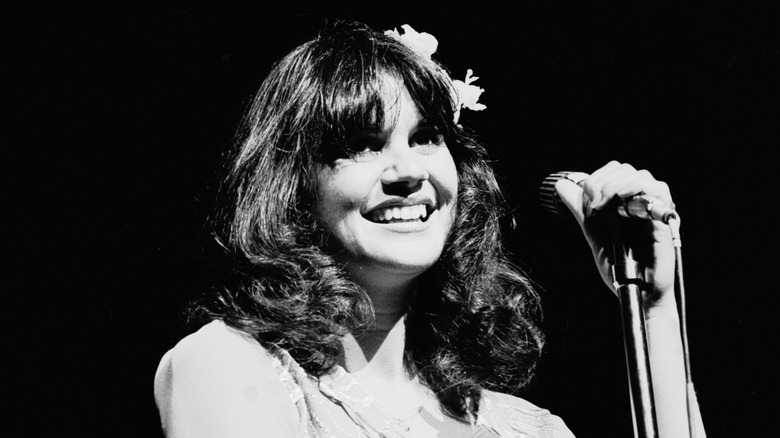 Linda Ronstadt smiling by mic on stage