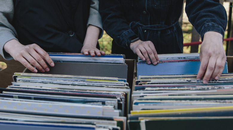 two people looking through stacks of records