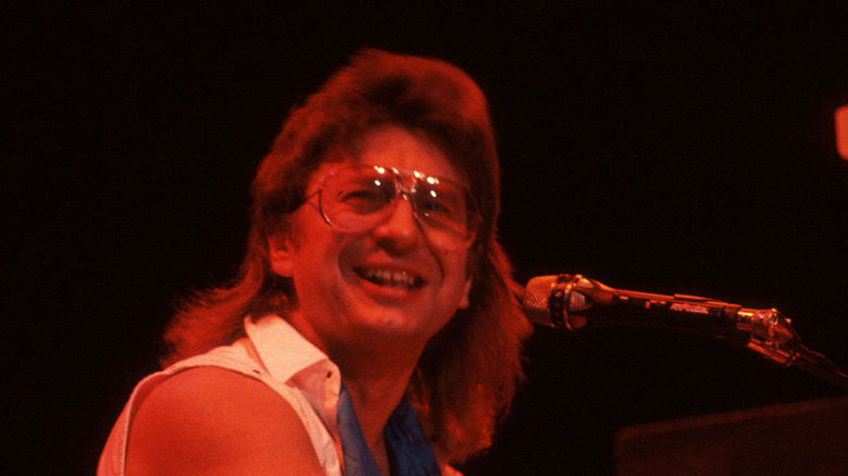 Jim Peterik sitting at keyboard and smiling