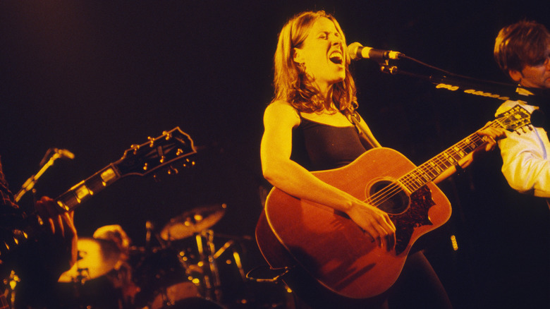 Sheryl Crow rocking out at concert on acoustic guitar