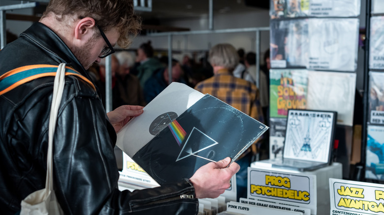 A man holding a dark side of the moon record in a record store