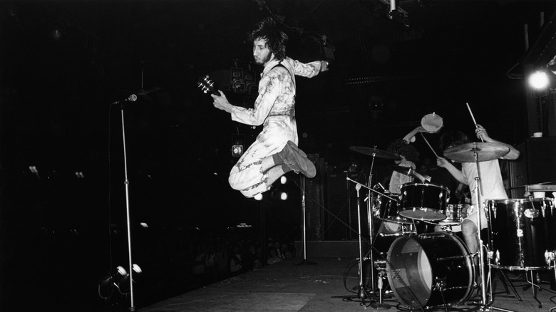 Pete Townshend of The Who jumping while playing guitar on stage