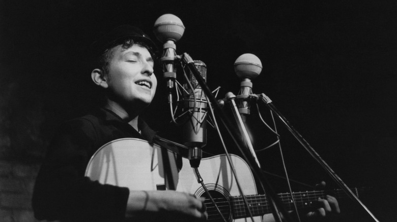 Bob Dylan with guitar in recording booth in 1961