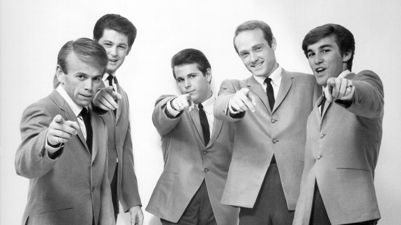 The Beach Boys posing in suits pointing at camera