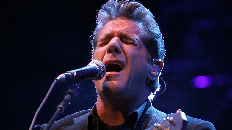 Glenn Frey singing and playing guitar with eyes closed onstage