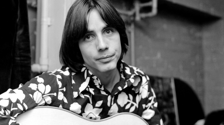 Jackson Browne posing for photo holding guitar