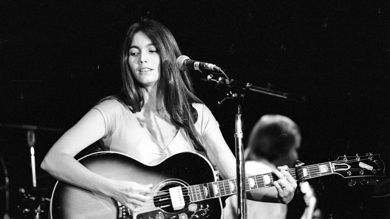 Emmylou Harris playing guitar and singing