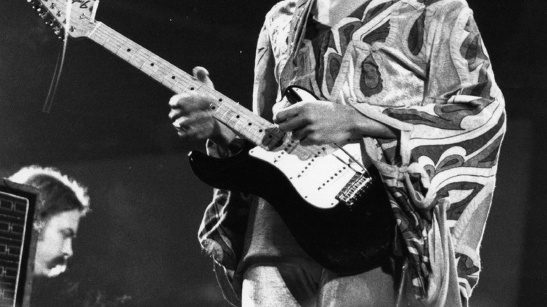 Jimi Hendrix playing guitar on stage during live performance