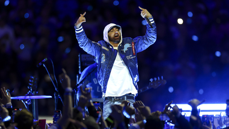 Eminem live on stage with hands raised