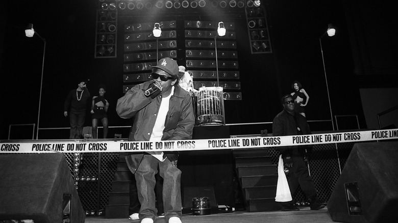Eazy-E rapping into mic on stage