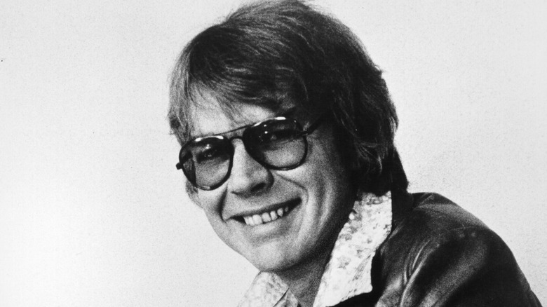 Bill Fries as CW McCall smiling in glasses and leather jacket