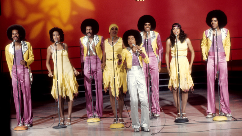 The Sylvers in yellow and purple outfits performing on stage