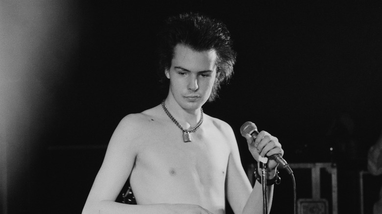 Sid Vicious holding a microphone onstage