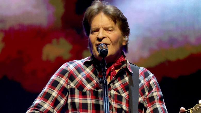 John Fogerty playing guitar in plaid shirt