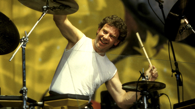 Bill Bruford smiling and playing the drums on stage