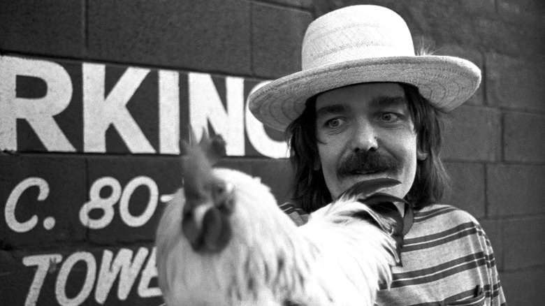Captain Beefheart wearing a hat and holding a rooster
