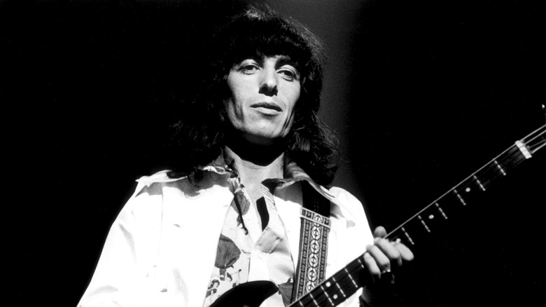 Bill Wyman standing on stage with guitar