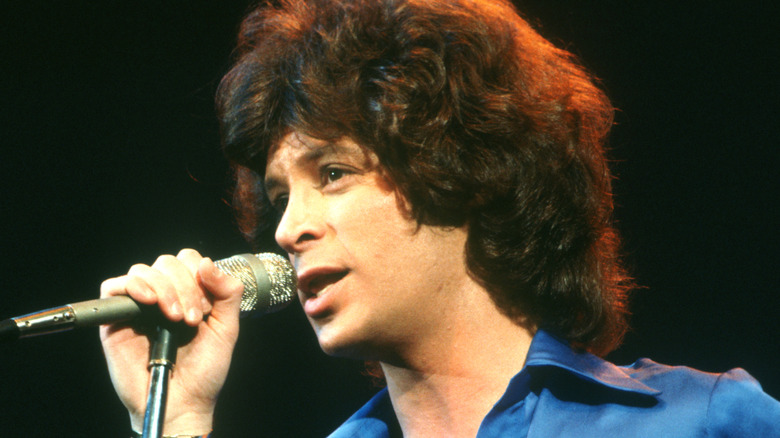 Eric Carmen singing on stage in blue shirt in 1970s