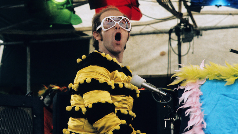 Elton John sat at piano in bee costume on stage