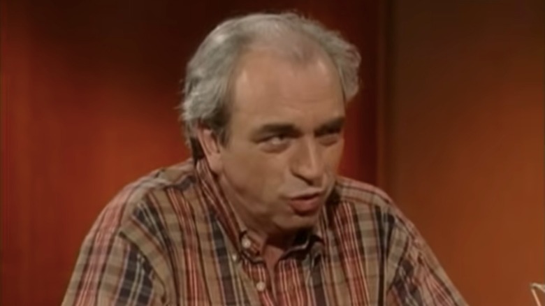 Julien Poulin in checkered shirt giving interview