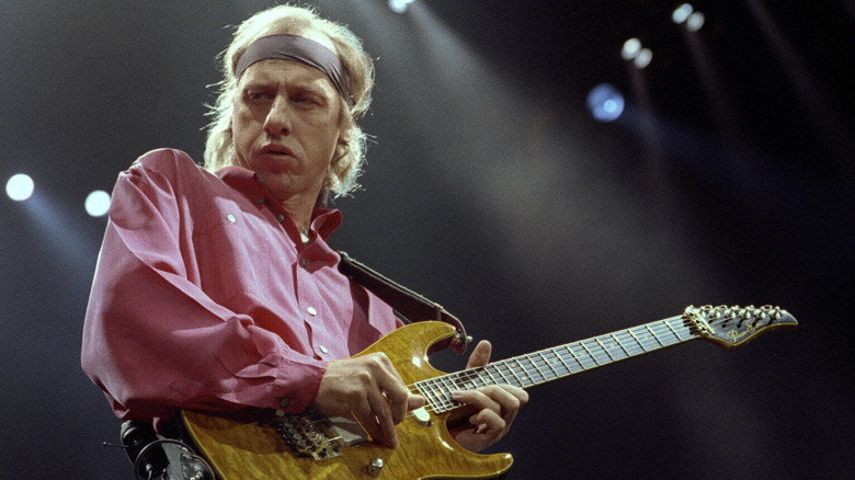 Mark Knopfler playing guitar on stage