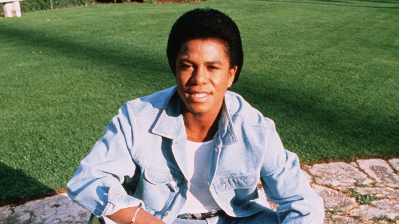 Jermaine Jackson in a jeans jacket in a field