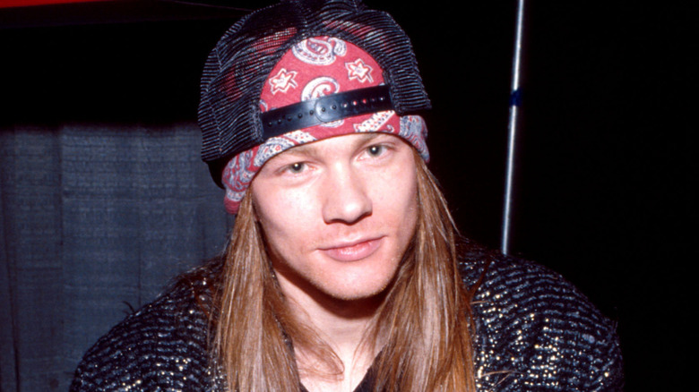 Axl Rose in the '80s in hat and bandana smirking