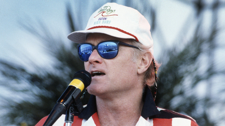 Mike Love singing onstage outside in the 1980s