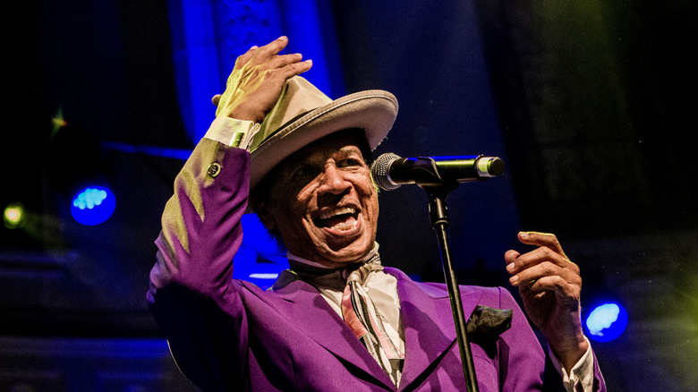 Kid Creole in a suit and fedora performing onstage