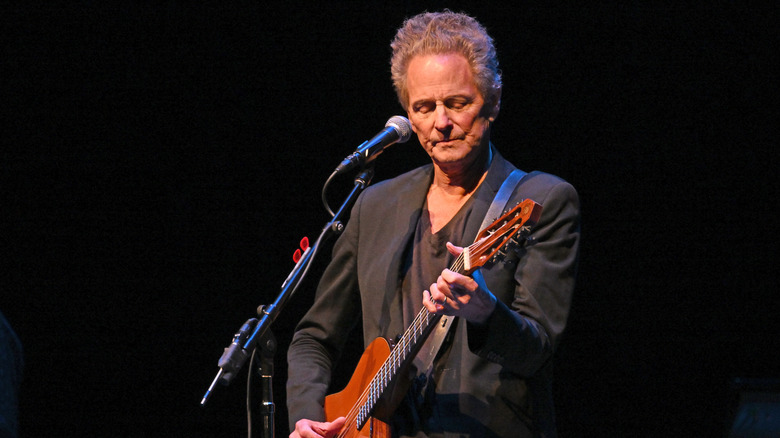 Lindsey Buckingham playing guitar on stage.