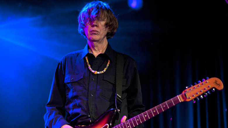 Thurston Moore on stage playing guitar.