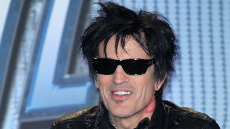 Tommy Lee with bedhead wearing sunglasses.