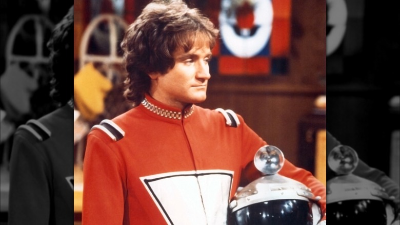Mork holding helmet