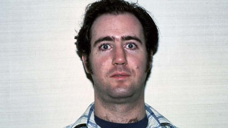 Andy Kaufman staring ahead in blue and white shirt