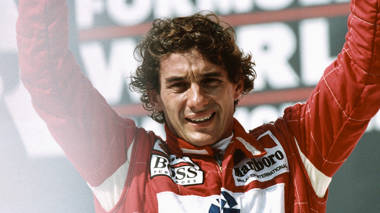 Ayrton Senna hoists arms in celebration after race