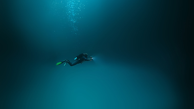 diver under water with flashlight
