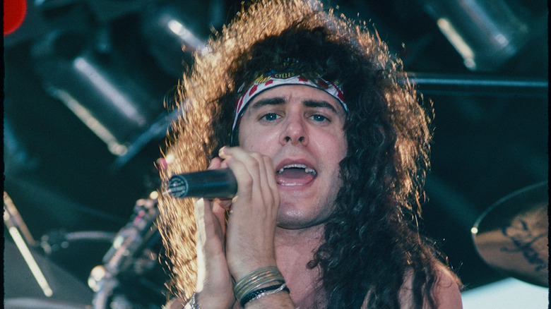 C.J. Snare with big hair singing on stage