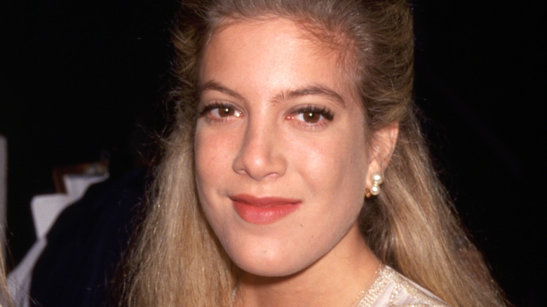 Tori Spelling smirking at 1990s event